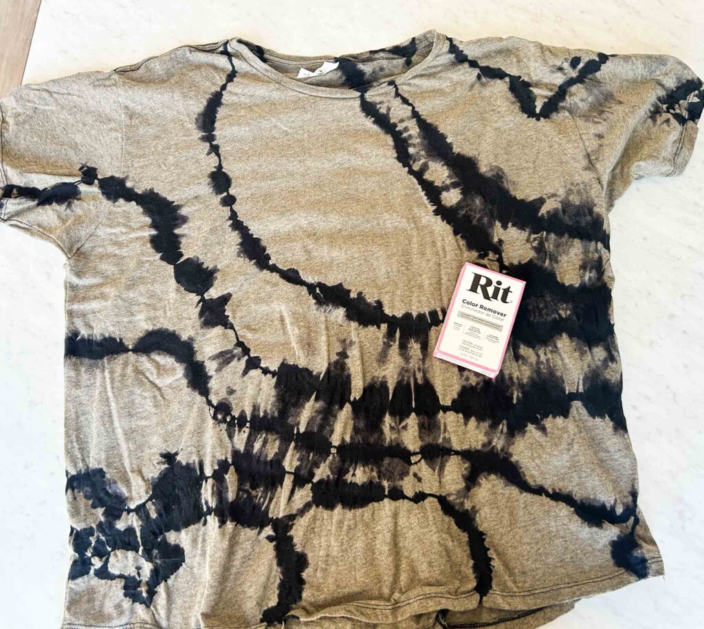 Gray t-shirt with black tie dye design shown with Rit Color Remover box