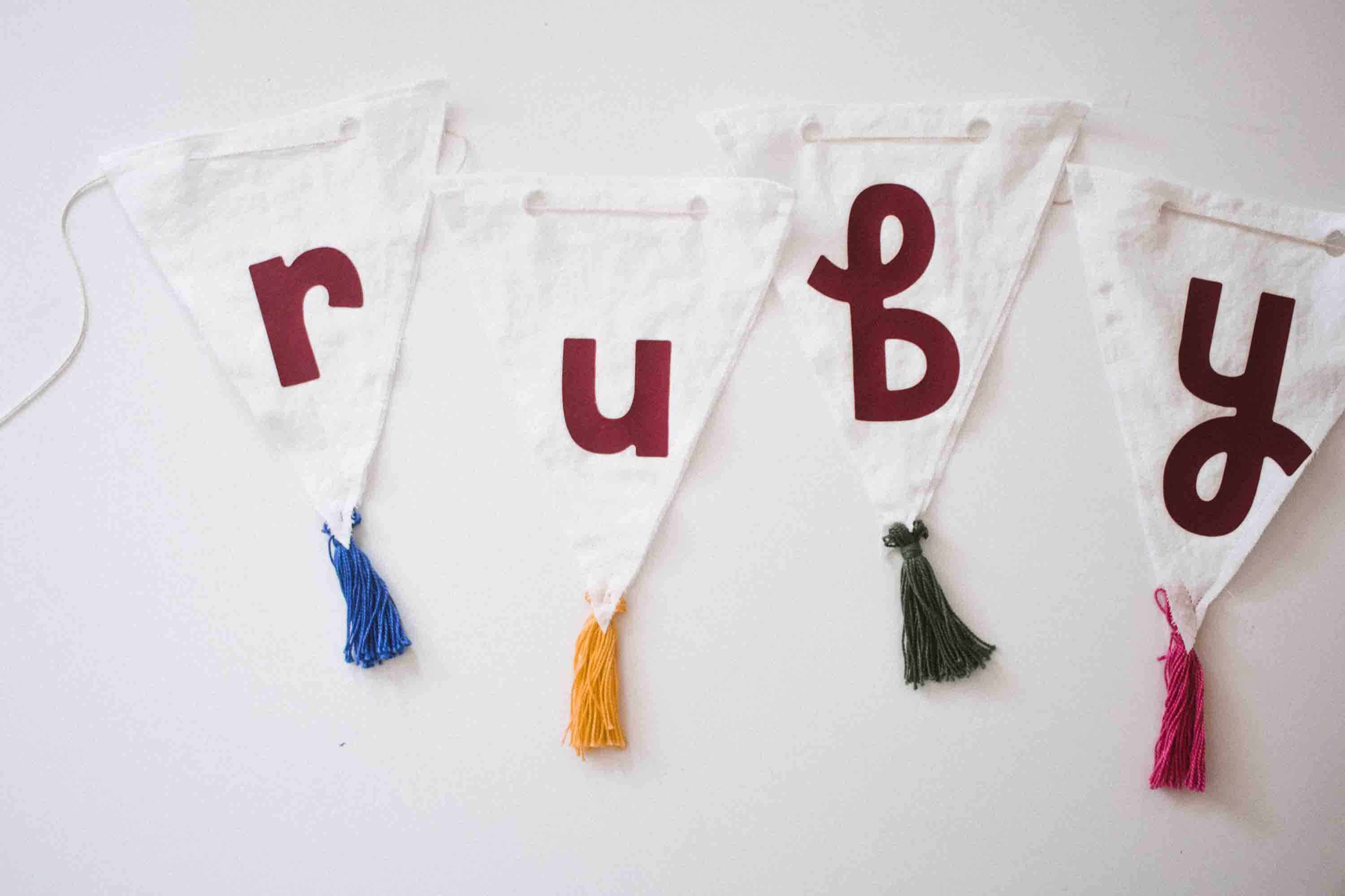 DIY a tassel banner for a birthday or any occasion! The one featured here was a baby name used above a crib and turned out so cute.