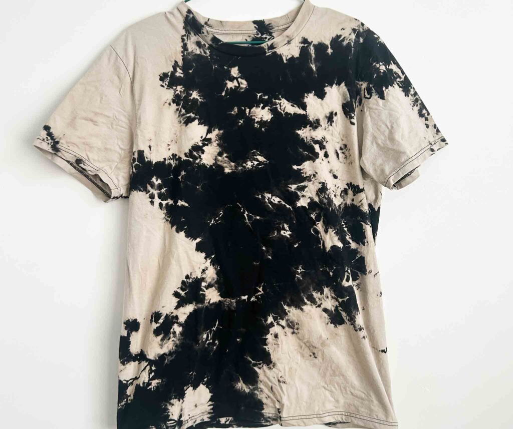 Reverse tie-dye t-shirt with black and beige patterns created using Out White Brite
