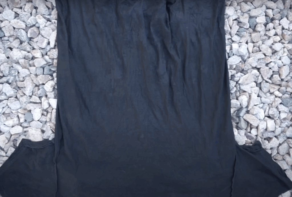 Black cotton shirt laid flat before reverse tie dyeing process using toilet bowl cleaner