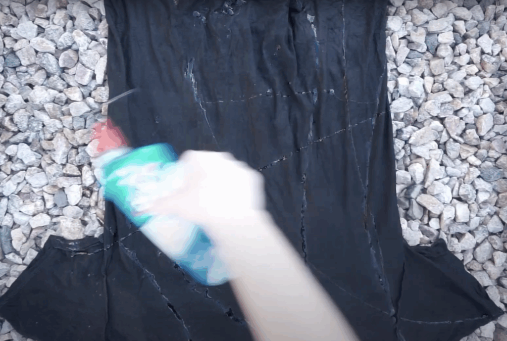 Squeezing toilet bowl cleaner onto black shirt to create reverse tie dye effect