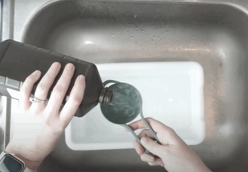 Pouring hydrogen peroxide into tub to neutralize bleach during reverse tie dye process