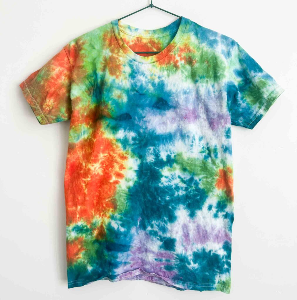 Colorful tie dye t-shirt featuring red, teal, purple, and green ice dye scrunch design