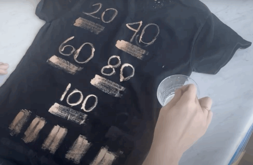 Black shirt fully painted with multiple bleach ratios, showing side-by-side results of each mixture