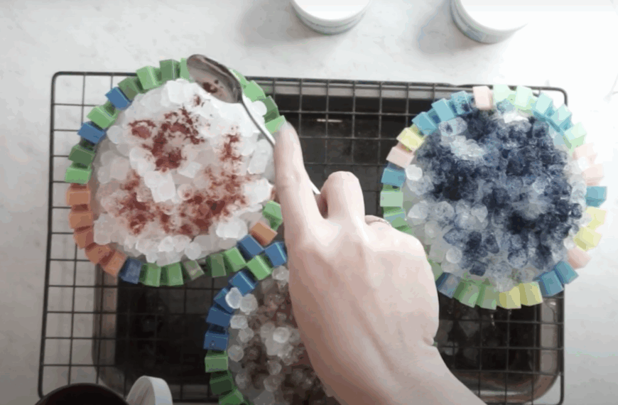 Close-up of ice dye setup with Dharma Rattlesnake, Blood Moon, and Snow Maiden powders sprinkled over crushed ice on cotton towels.