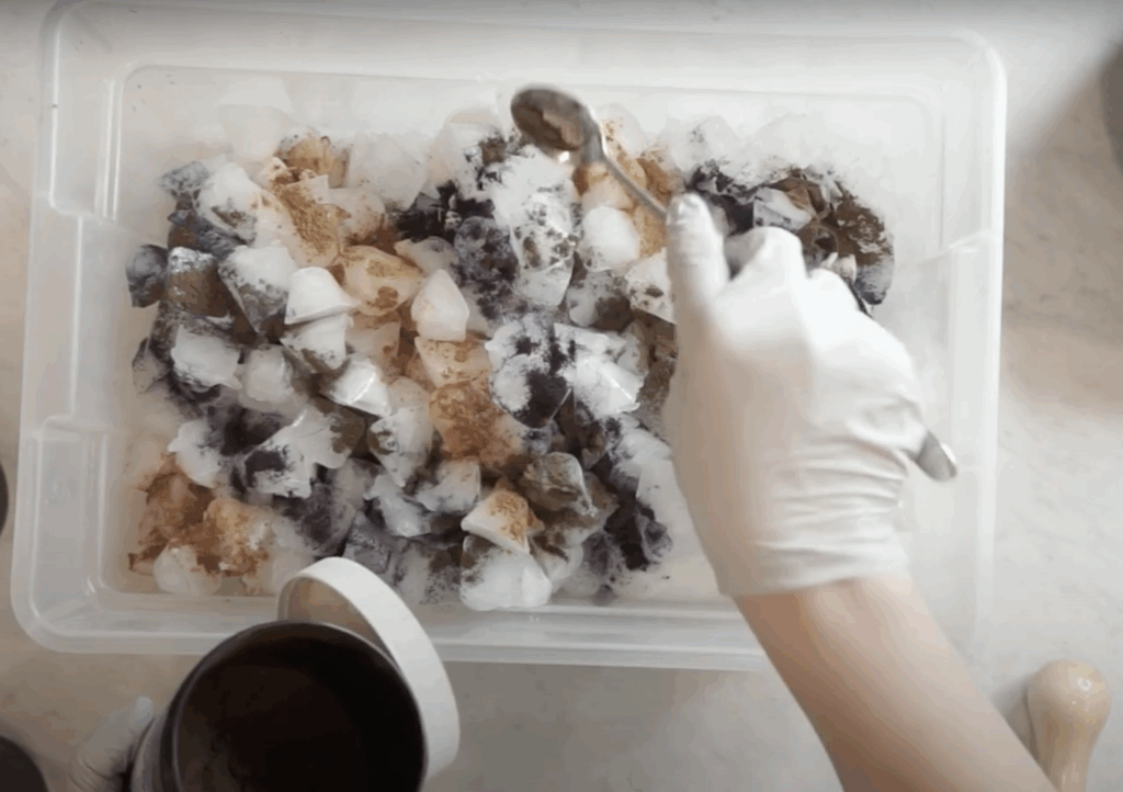 Sprinkling powdered dye over ice-covered hoodie for ice dye tie dye technique