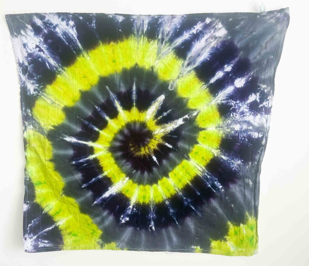 Finished Halloween spiral tie dye towel with neon yellow, purple, and black rings for a bold festive design
