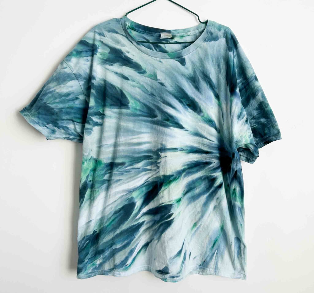 Fan fold ice dye technique shirt with blue and green streaked pattern and soft flowy texture