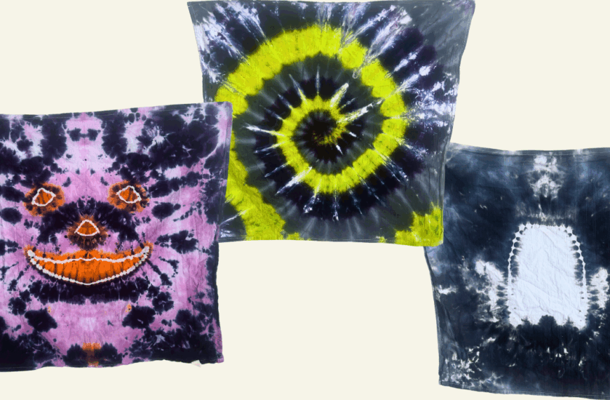 Three finished Halloween tie dye towels showing different designs — a jack-o’-lantern face, neon green spiral, and white ghost silhouette created with the hot water irrigation method.
