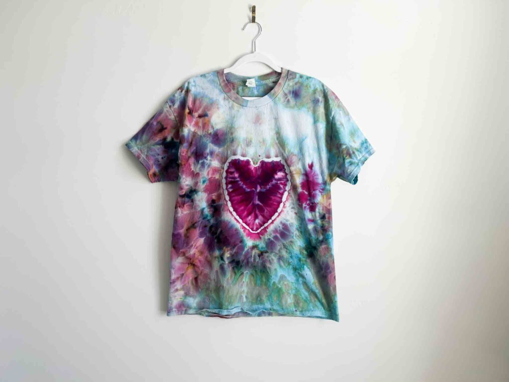 Heart tie dye shirt with pink and purple design showing a symmetrical heart shape in the center.