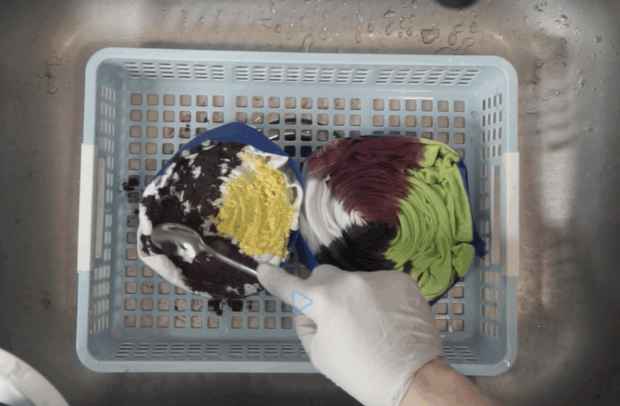 Applying powdered and liquid dye side by side during a hot water immersion tie dye comparison using lime, purple, and black dyes.
