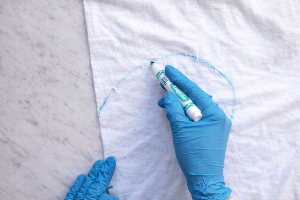 Drawing half a heart on a folded white shirt with a washable marker for a heart tie dye pattern