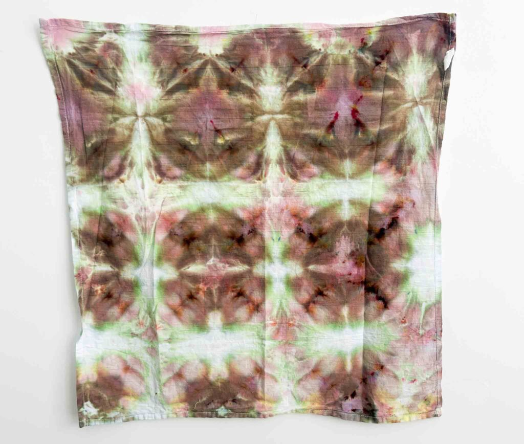 Finished shibori towel dyed with Jacquard ice dye in the Spamone color showing earthy brown and green tones