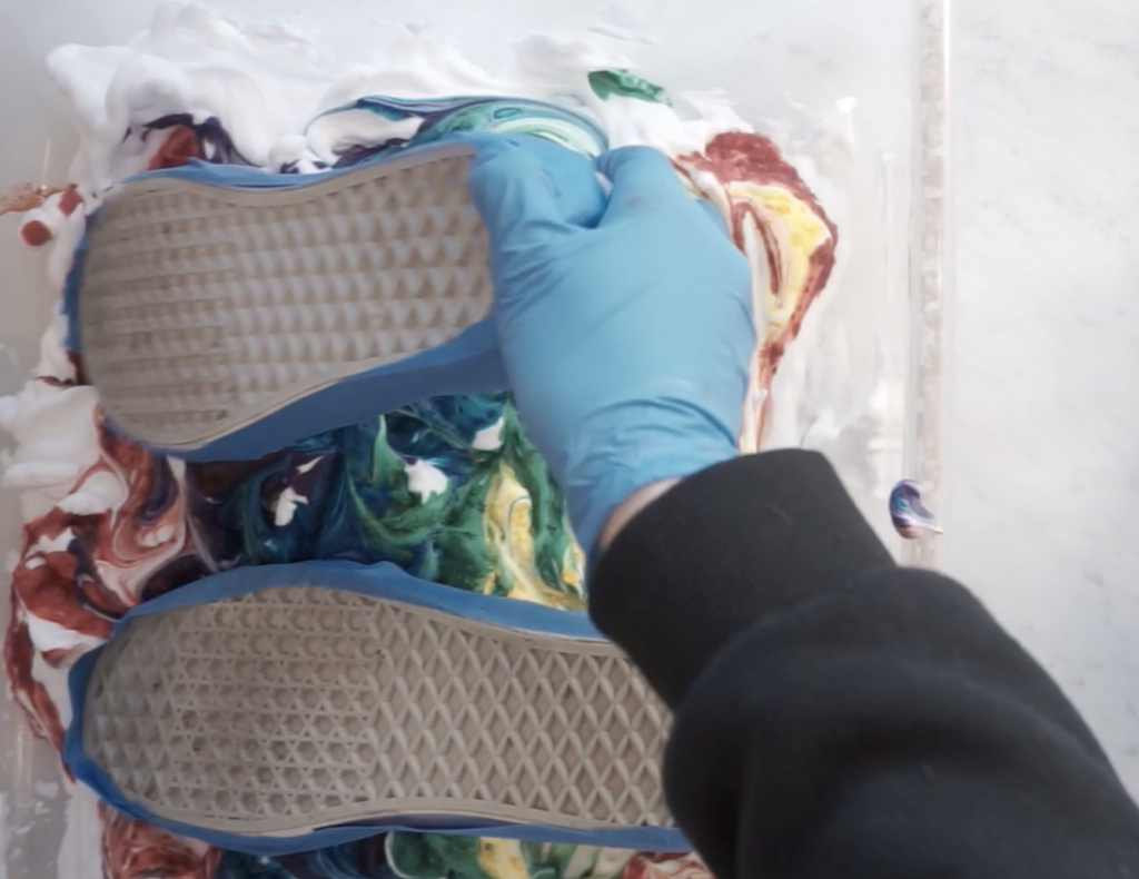 Canvas shoes pressed into shaving cream tie dye mixture to transfer color