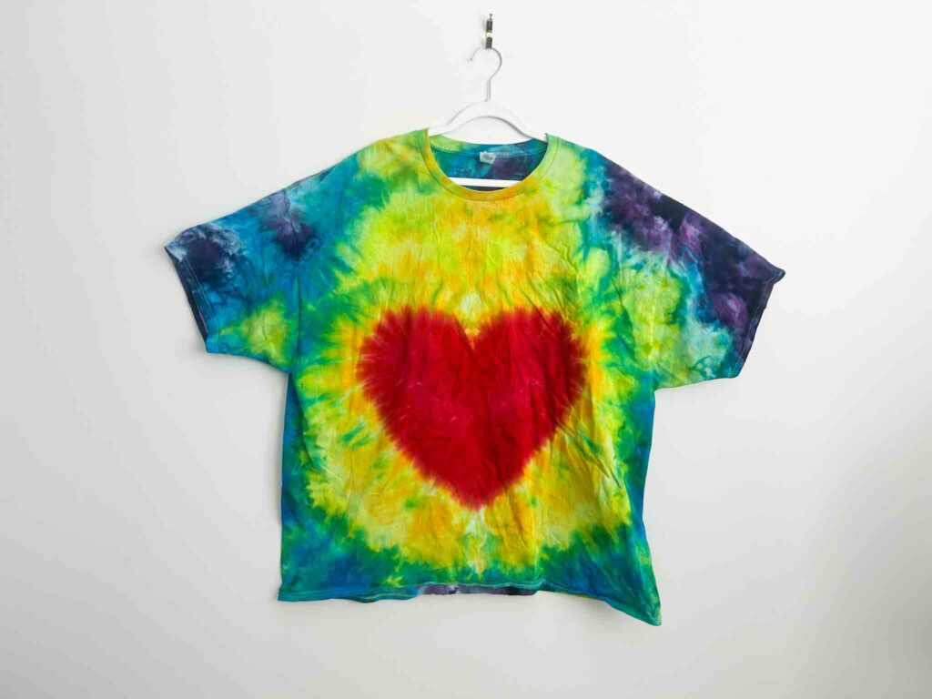 Rainbow heart tie dye shirt with red heart center and bright ice dyed background