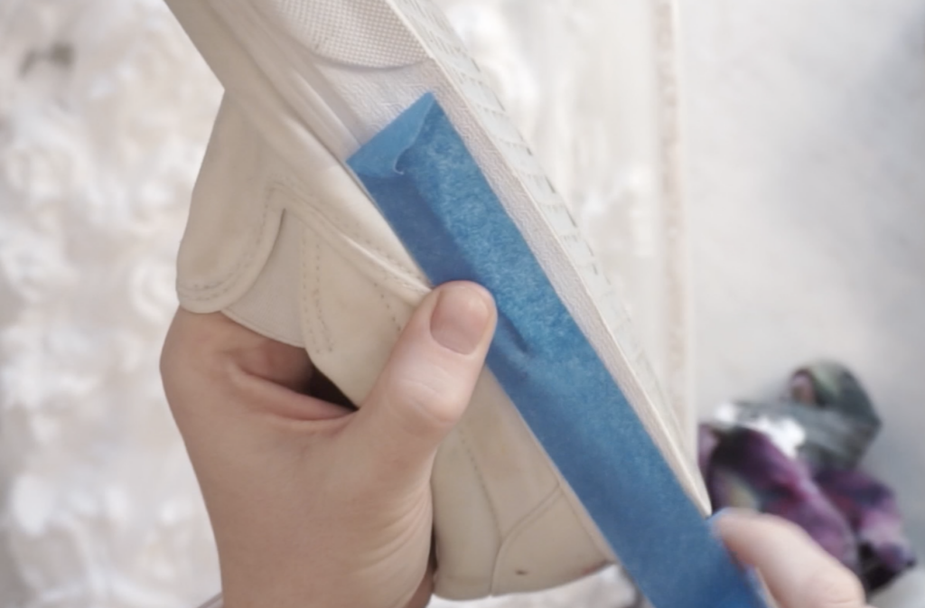 Painter’s tape protecting rubber soles before shaving cream tie dye on canvas shoes