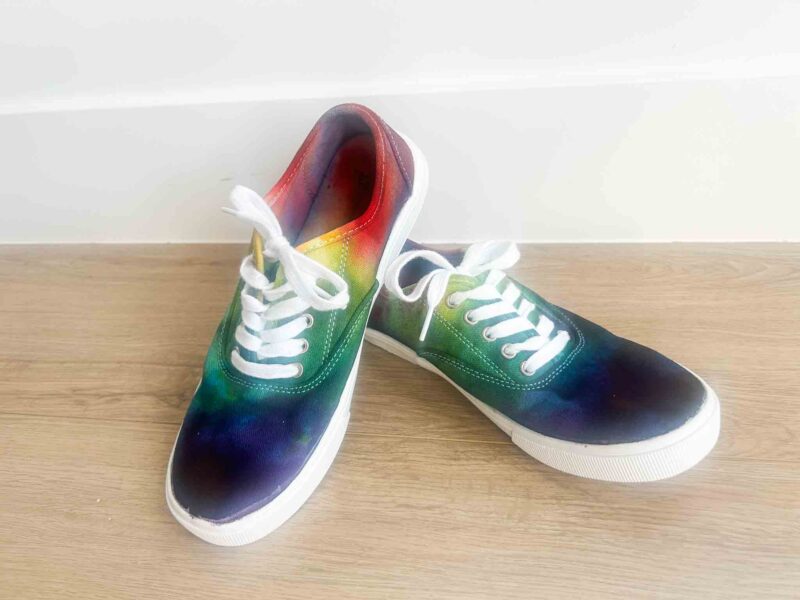 Rainbow gradient tie dye canvas shoes created using the Sharpie tie dye technique, showing vibrant blended colors on lace-up sneakers.