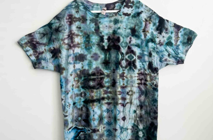 Ice dye glitch fold t-shirt with repeating geometric pattern in teal, navy, and black