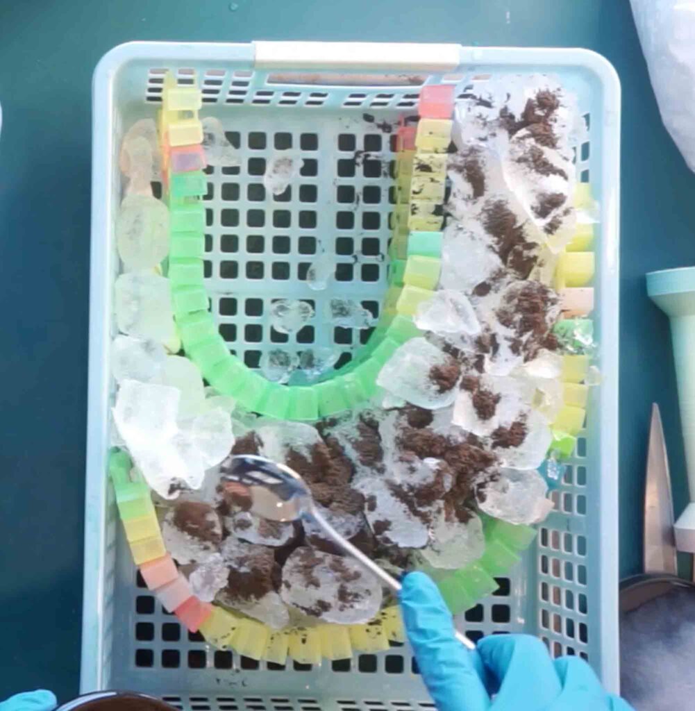 Ice dye bullseye tie dye setup using Magic Tracks as a barrier with black dye powder sprinkled over ice