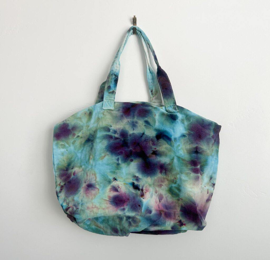 One color ice dye canvas tote in Alchemist, a blue dye that splits into green and purple