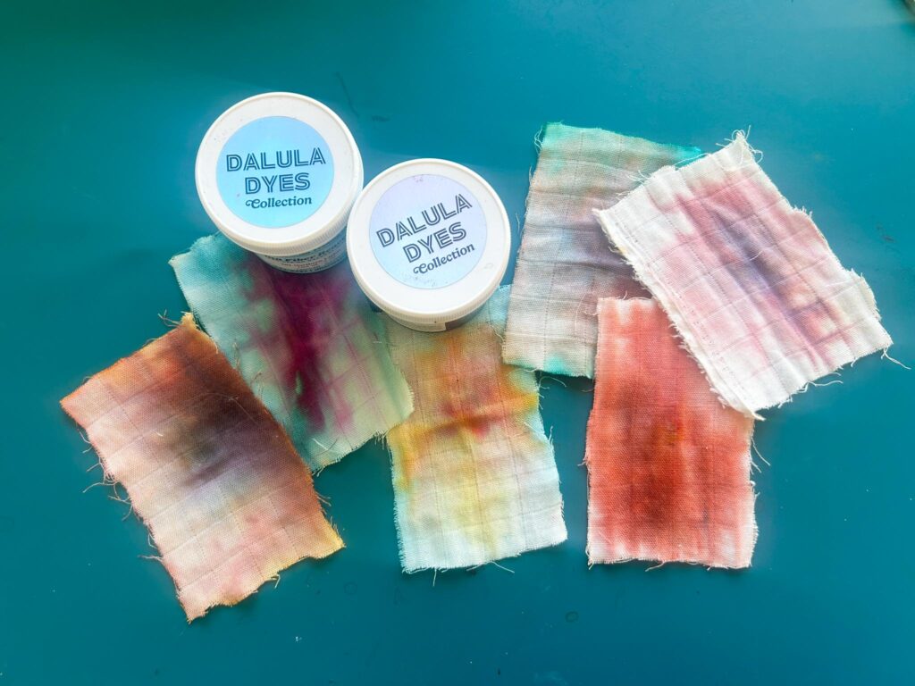 Dalula Dyes ice dye powder jars next to small fabric color test swatches