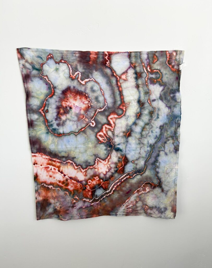 Moody Fire Dharma ice dye swatch showing red-orange sinew lines against a hazy green background