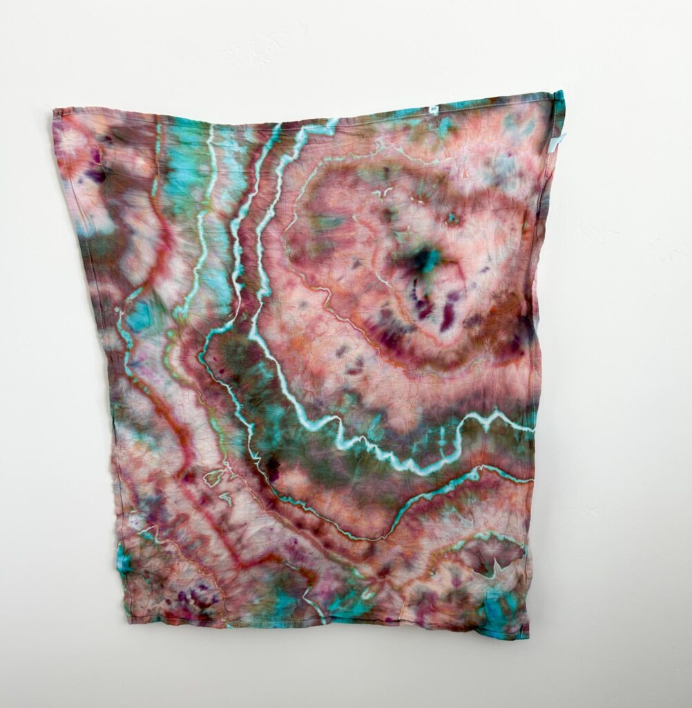 Rusted Blue Dharma ice dye swatch in turquoise and dusty red-pink