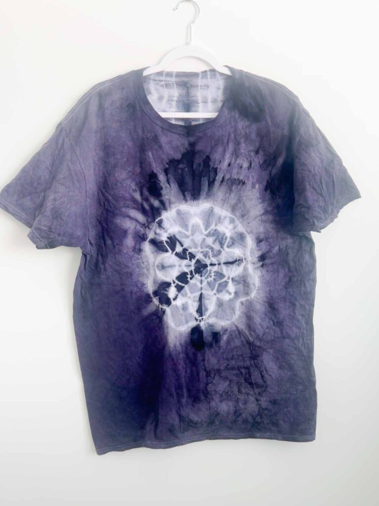 Finished purple mandala shirt after dyeing with logwood, shown on a hanger