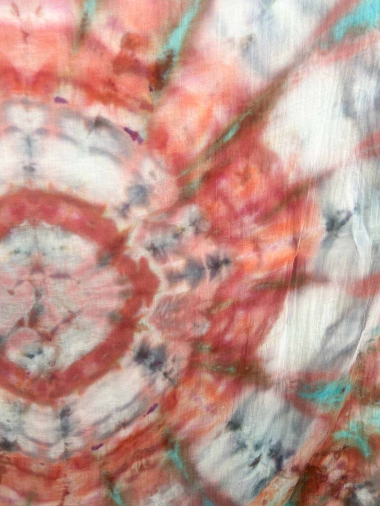 Close-up detail of a kaleidoscope tie dye pattern showing radiating color bands