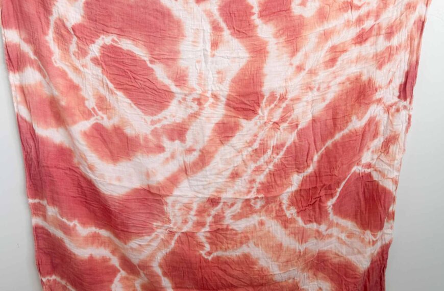 Finished swaddle with a deep red and coral shibori pattern using madder root dye