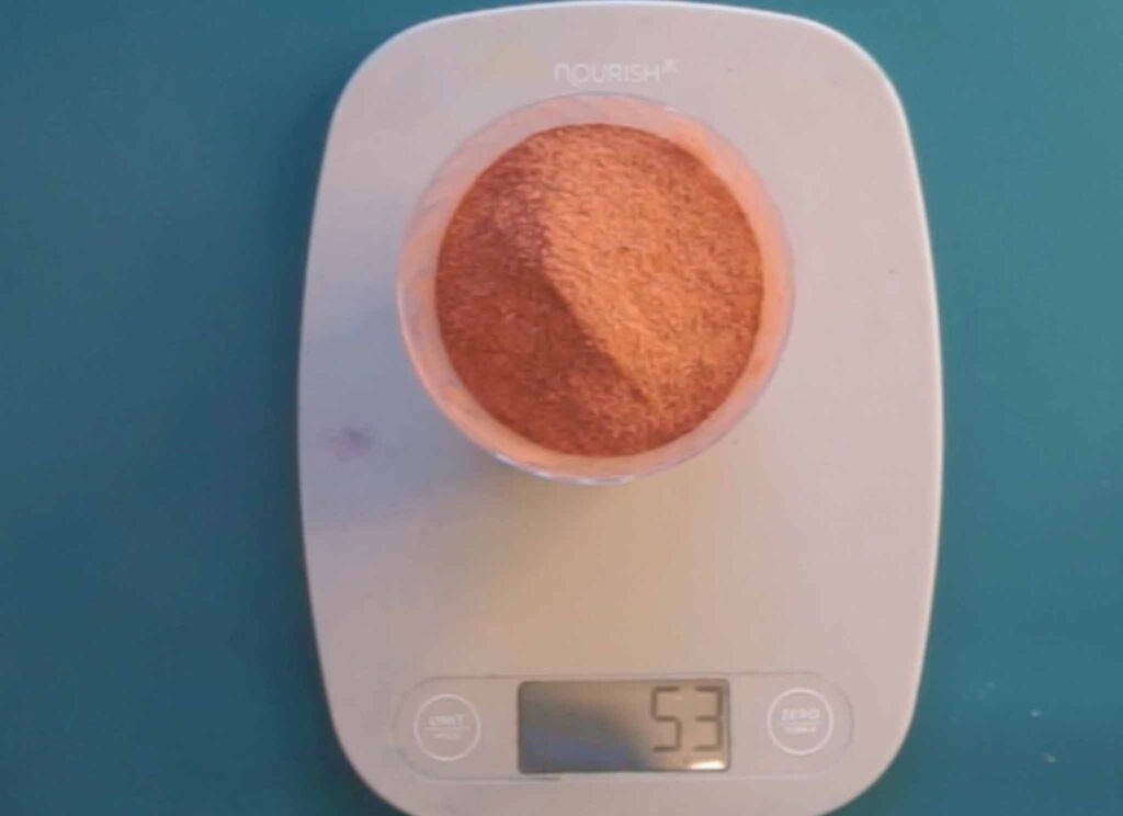 Madder root powder weighed on a kitchen scale for a natural dye pot