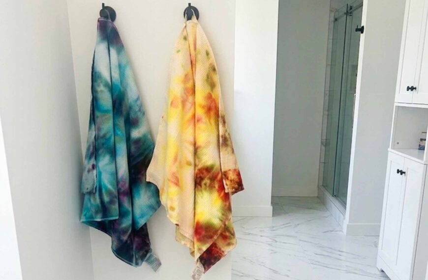 Cool toned and warm toned tie dye beach towels hanging side by side on wall hooks