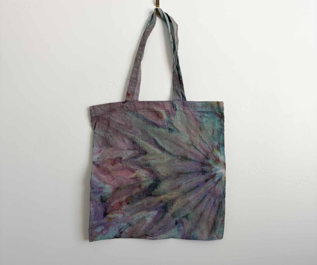 Finished ice dye fan fold tote bag with a fanned purple and teal pattern