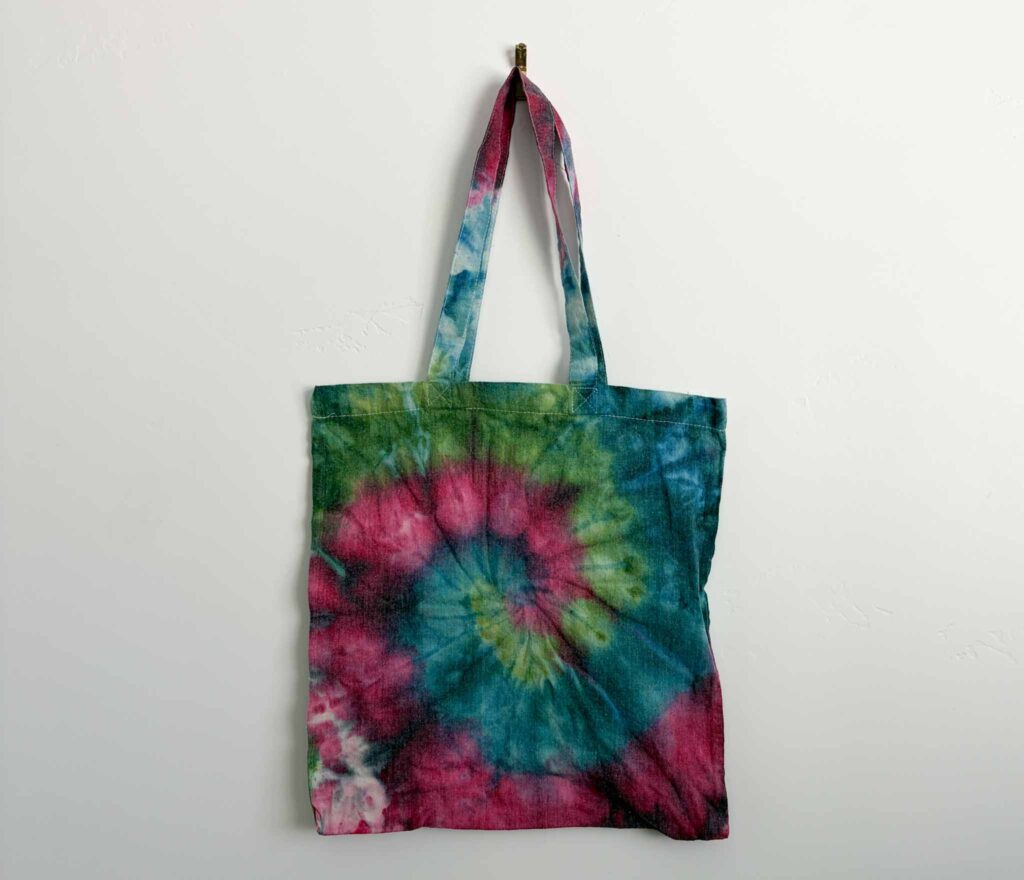Finished ice dye spiral tote bag in teal, pink, and green