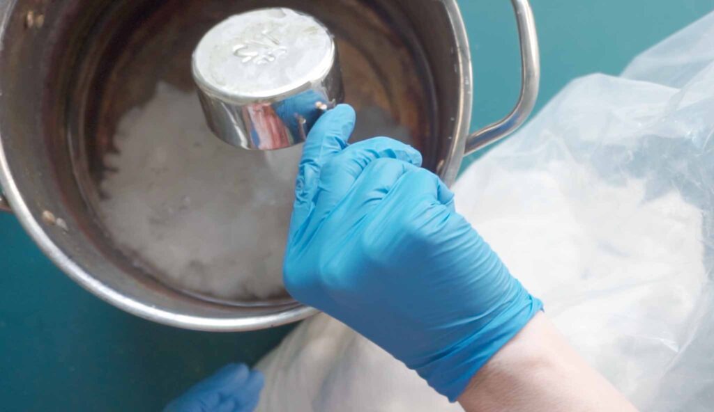 Measuring soda ash powder to mix into a tie dye soda ash solution