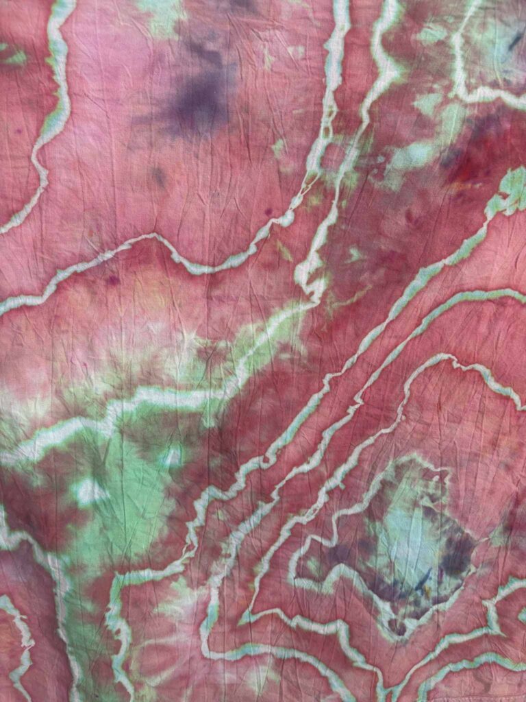 Close-up of Mint Berry ice dye with berry pink, mint green along the sinew lines, and a few purple spots
