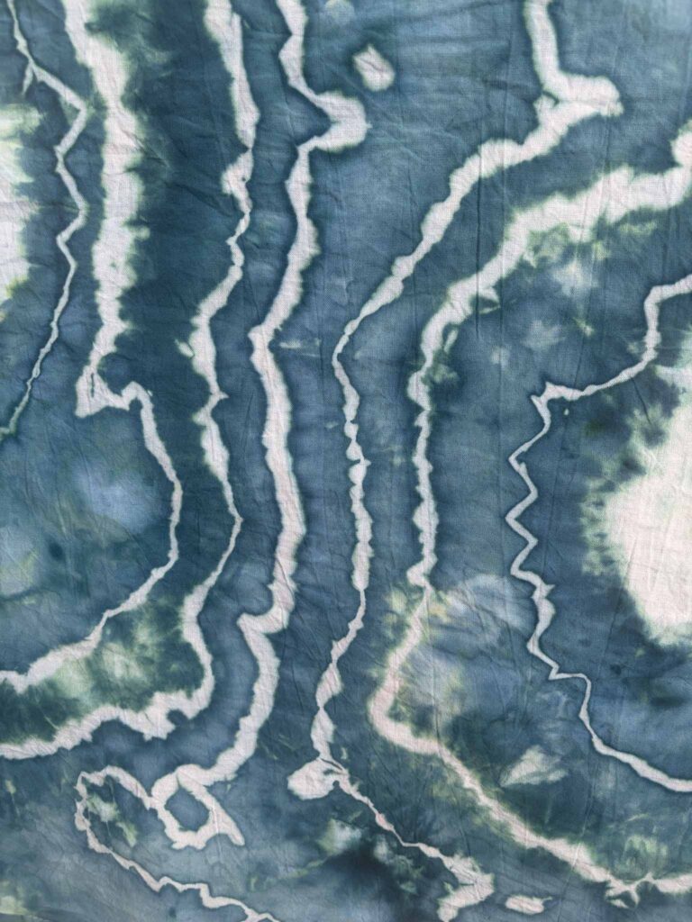 Close-up of Undertow ice dye showing deep teal with hints of seafoam green between jagged white sinew lines