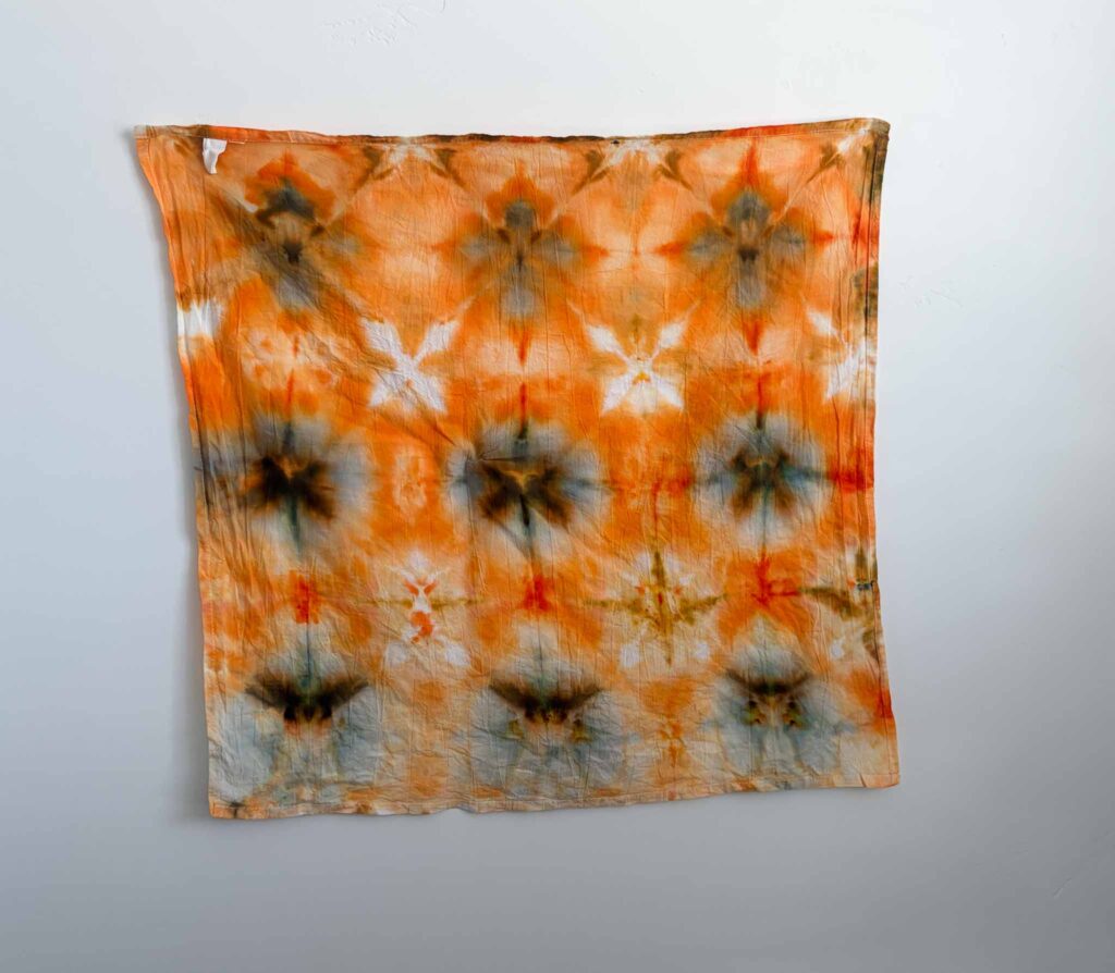 Fall tie dye shibori fold in bronze, soft orange, and amber waves resembling scattered leaves