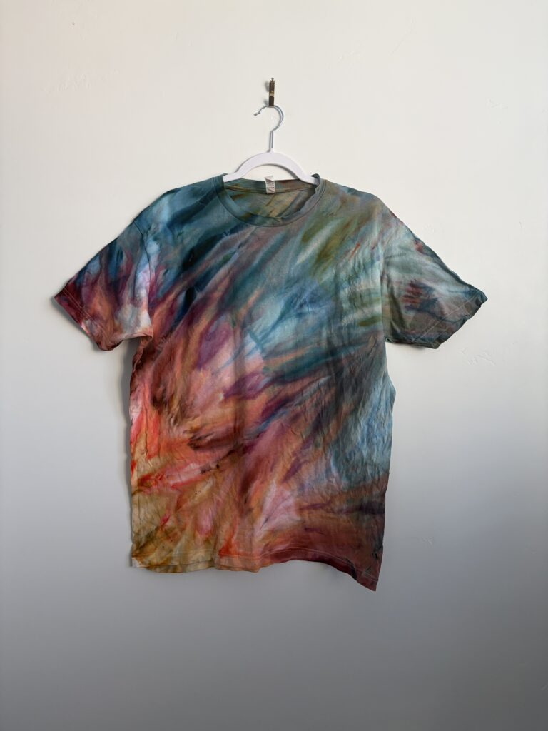 Back view of fern fold ice dye shirt showing blue, orange, and teal color blend