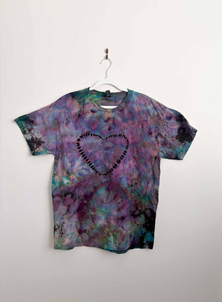 Reverse tie dye shirt with a heart pattern and purple, teal, and pink color added back in