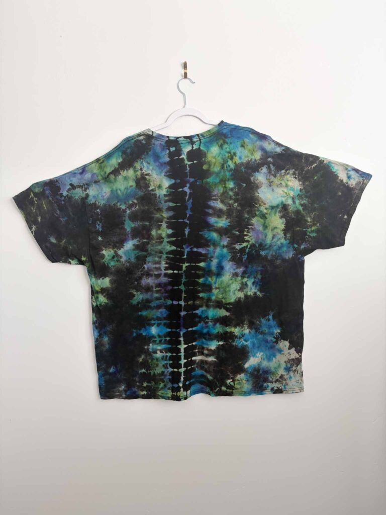 Back of a reverse tie dye shirt showing a spine pattern in blue and green