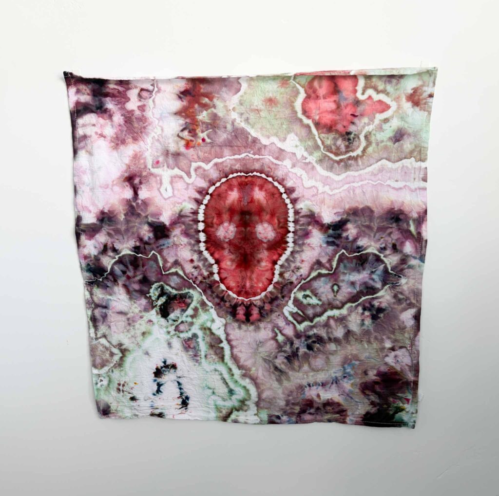 Red ice dyed skull tie dye towel with a white outline and a mauve, maroon, and sage geode pattern around it